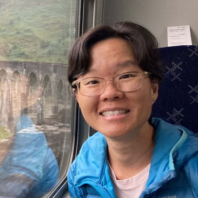 Portrait of Hannah, an ethnic Chinese woman with short hair wearing glasses.